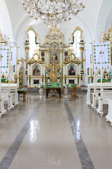 Interior of a modern Orthodox church with an iconostasis, throne and banners.