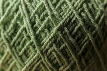 Cozy close up texture of green wool yarn. textile background showing an intricate pattern of fiber and thread, perfect for calm knitting or craft hobby