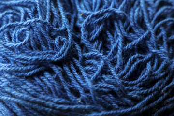 Macro closeup view of tangled blue yarn creating textured background. wool fiber detail shows complexity of thread, ideal for crafting or knitting concepts