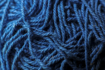 Close up macro texture of blue yarn wool background. Soft, warm material for knitting, craft, and sewing. Intricate, cozy fiber with an abstract pattern and textile detail
