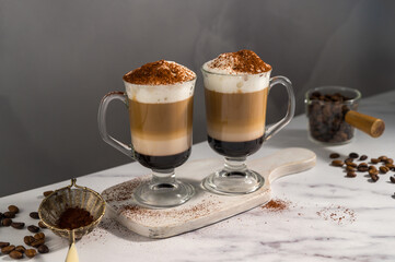 Layered coffee latte drinks. Hot coffee drinks in glass mugs, dark background