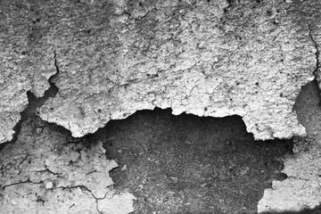 Abstract black and white background of peeling, cracked wall with rough texture. Grunge concrete surface showing decay and signs of aging with an old weathered pattern