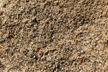 Detailed macro texture of brown beach sand background. This natural, grainy, and coarse surface creates calm, earthy, and abstract feeling for any design project