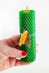 Natural wax candle with bay leaf and dried orange for cleansing rituals and wish fulfillment