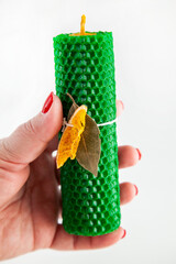 Natural wax candle with bay leaf and dried orange for cleansing rituals and wish fulfillment