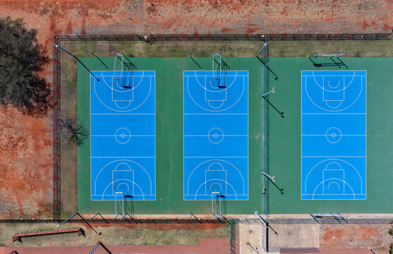 three blue outdoor multi-use courts seen from above