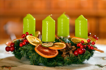 advent wreath decorated with candles, candy canes, dried oranges and pine cones