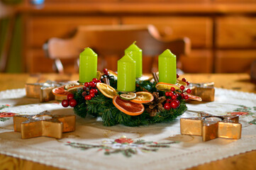 advent wreath decorated with candles, candy canes, dried oranges and pine cones