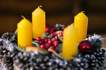 advent wreath decorated with candles, candy canes, dried oranges and pine cones