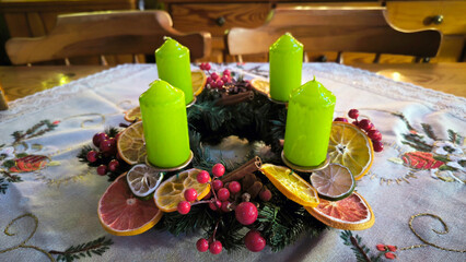 advent wreath decorated with candles, candy canes, dried oranges and pine cones