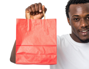 A smiling man holds a bright red shopping bag, showcasing his purchase against a dark background.