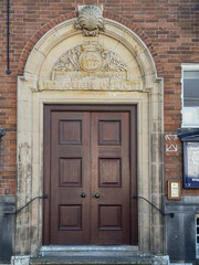 Newcastle-under-Lyme, Staffordshire-united kingdom March, 09, 2025 Historic Borough Police Doorway Arch in Newcastle-under-Lyme with Stone Crest Over Wooden Doors