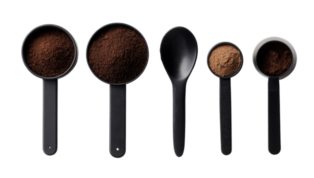 Black measuring cups and spoon, filled with ground coffee
