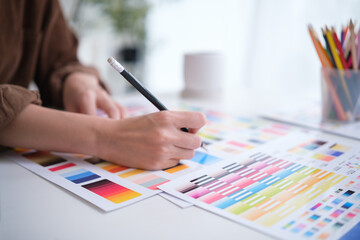 Close-up of a creative professional selecting shades from colorful swatches during a design process.