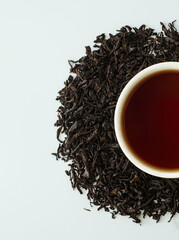 Composition with various types of tea, a cup of brewed tea, and loose tea on a white background