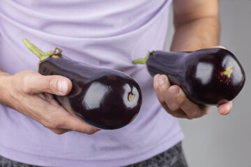 Man's hand holding eggplant close up