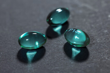 Blue supplement capsules isolated on dark background