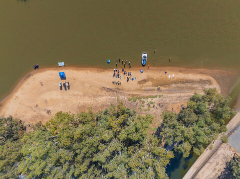 Aerial view of 4wds and watercraft on the sandy shores of an inland river at Moama, New South Wales
