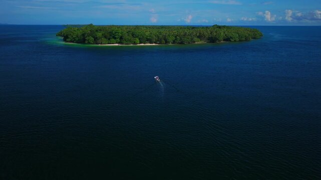 Fishing boat Yuo Island remote pristine untouched tropical coastline village Wewak Madang Cape Wom Papua New Guinea aerial drone PNG dry season summer morning blue sky follow forward pan up motion