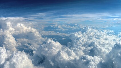 High-altitude view of vast, puffy clouds. Vast expanse of cumulus clouds with varied formations, illuminated by sunlight. Clear blue sky interspersed with the clouds