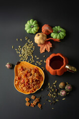 Autumn composition with pumpkin candies, cups of tea and pumpkins on a dark background in Halloween style