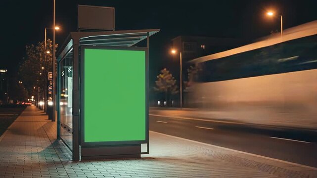 Green screen billboard at a bus stop at night with a blurred bus passing by, perfect for advertising mockups and creative content