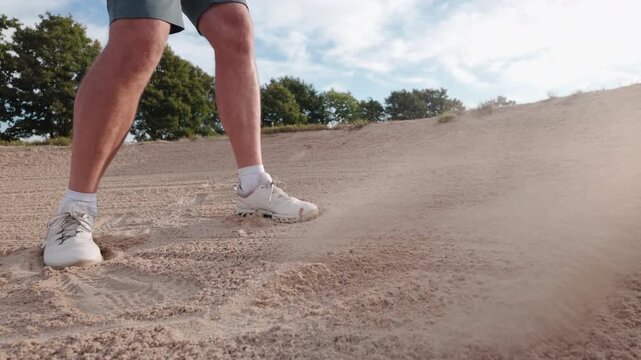 Golfer hitting a ball out of a sand bunker