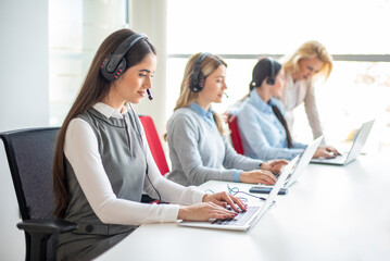 Businesswoman and agents typing at laptops