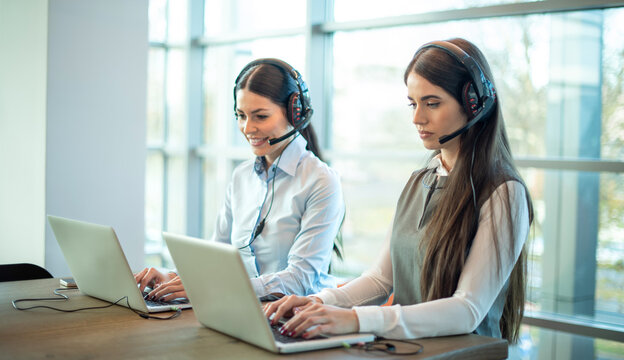 Customer support representatives collaborating with advanced communication technology in modern office - Powered by Adobe