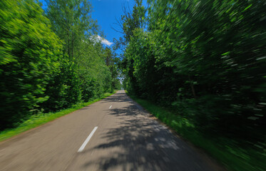 Obraz premium The effect of speed on the road and blur. View of the road on a summer day.