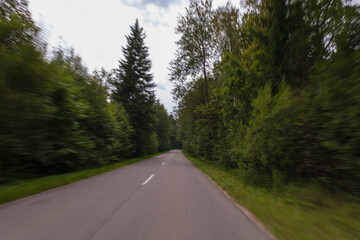 Naklejka premium The effect of speed on the road and blur. View of the road on a summer day.