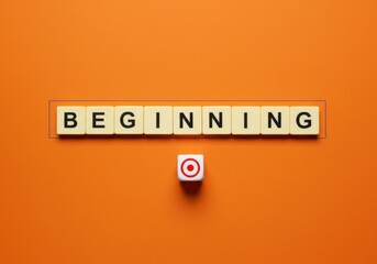 Scrabble tiles spelling beginning with a target symbol on a vibrant orange background