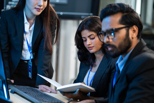 Diverse software engineer analysing and reviewing data on document in the tech office. Developer team planning project for programming application. Cybersecurity center and IT innovation