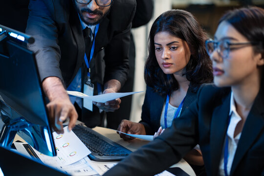 A technical consultant is providing expert guidance to diverse team. Pointing directly to a report containing data visualization while working at a computer. strategic planning, work collaboration - Powered by Adobe