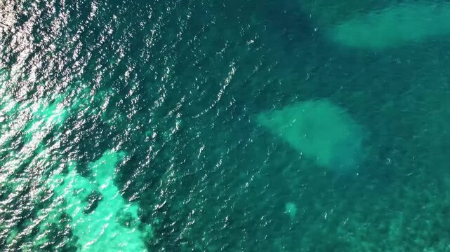 aerial footage captures the crystal clear turquoise waters of the Aegean Sea, showcasing the vibrant marine life and underwater topography near the Dat&ccedil;a Peninsula, Turkey. This breathtaking view is f