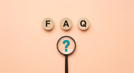 Magnifying glass focusing on a blue question mark below the letters FAQ displayed on three wooden circular blocks against a peach background