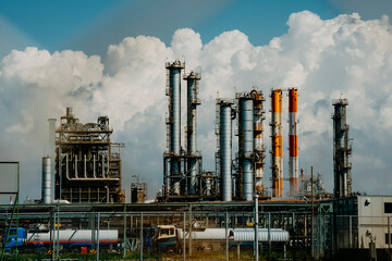 劇的な雲と高層煙突が連なる工場地帯の風景