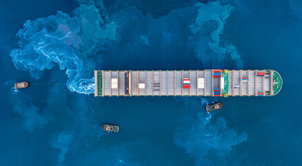 Aerial top view container ship and tugboat towing freighter in harbor for import export logistics in port.
