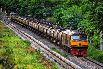 Railroad train of tanker cars transporting crude oil on the tracks.
