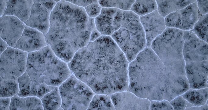 Crusty cracked salty plain on the ground. Top view. Footage over the Bonneville salt flats in Utah, USA.