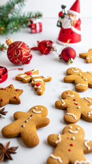 Festive arrangement of gingerbread cookies and Santa Claus figurine on light surface, evoking warm holiday cheer and celebration

