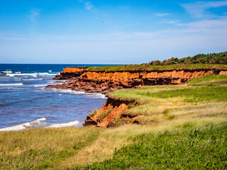 Rugged red cliff coast in Prince Edward Island National Park on the north shore of Prince Edward...