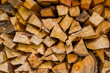 Stacked firewood logs arranged in a rustic pattern showcasing natural textures and warm tones for cozy ambiance