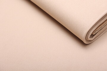 Top down close-up view of soft cashmere wool coating fabric in warm beige color perfect for autumn fashion, fall textures, and seasonal textile design. 
