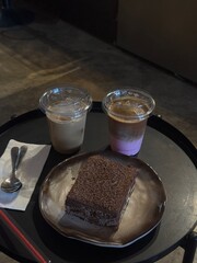 two cups of latte and tiramisu on the black table