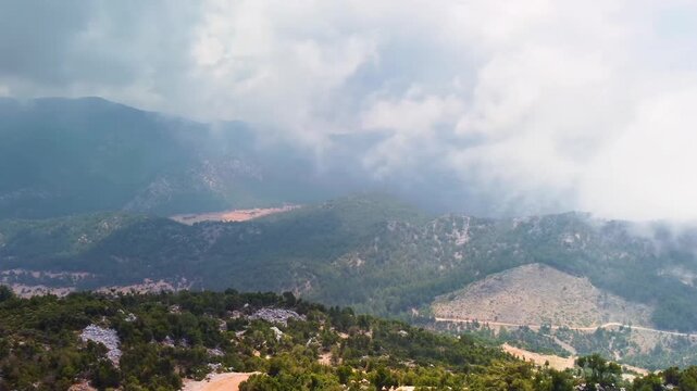 aerial or high angle footage showcasing the majestic Babadag mountain range and the iconic Kelebekler Vadisi Butterfly Valley nestled below, near Fethiye, Turkey. Capturing the dramatic landscapes, lu