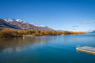 Obraz premium scenic view of wakatipu lake with colorful autumn leave tree and snow cap mountain background Glenorchy South Island New Zealand