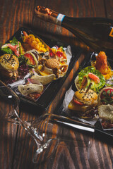 Finger sharing food on tray. Bugers, samos. Kolacja. 