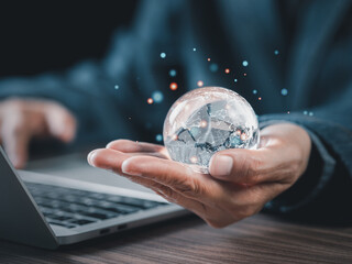 Businessman holding glass blobe with icon global network connections in the office. Big data analytics and business intelligence concept. World map point and line composition in clear glass ball.