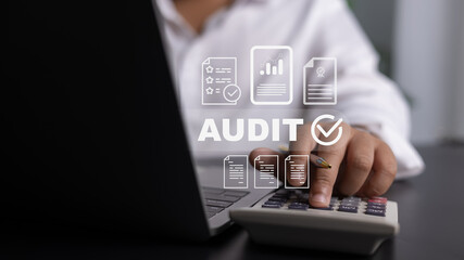 Close-up of calculator and laptop with AUDIT digital overlay for financial compliance
